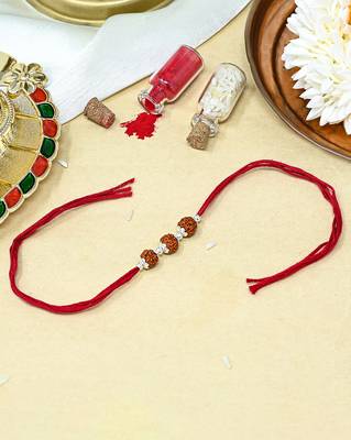 Red thread rakhi with three rudraksha beads and silver accents 1