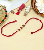 Red thread rakhi with three rudraksha beads and silver accents