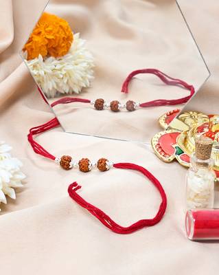 Red thread rakhi with three rudraksha beads and silver accents 3