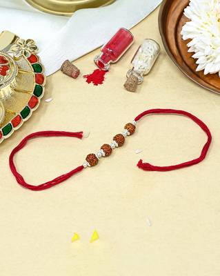 Red thread rakhi with four rudraksha beads and silver detailing 1