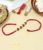 Red thread rakhi with four rudraksha beads and silver detailing