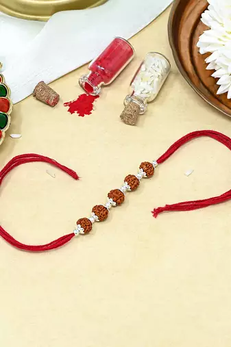 Red thread rakhi with five rudraksha beads and silver detailing