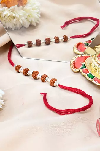 Red thread rakhi with five rudraksha beads and silver detailing