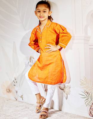 Girl's traditional raksha bandhan outfit - orange cotton kurta with white leggings set for casual festival wear 1