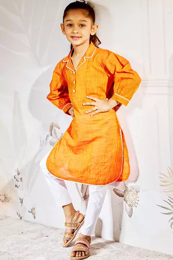 Girl's traditional raksha bandhan outfit - orange cotton kurta with white leggings set for casual festival wear