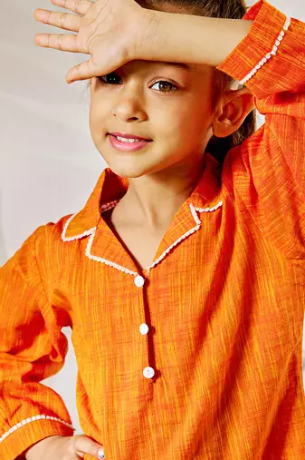 Girl's traditional raksha bandhan outfit - orange cotton kurta with white leggings set for casual festival wear
