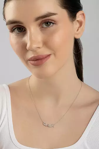 Engraved silver pendant necklace with 'good luck' inscription and sleek design