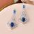 Silver-plated blue stone drop earrings with american diamond