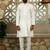 Silk blend solid cream kurta and churidar with floral green nehru jacket