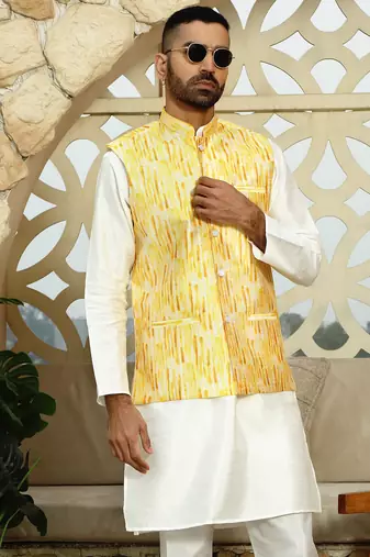 Silk blend solid cream kurta and churidar with tie-dye yellow nehru jacket