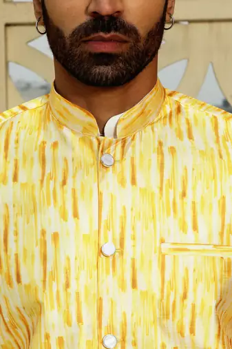 Silk blend solid cream kurta and churidar with tie-dye yellow nehru jacket