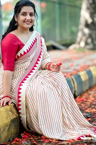 Elegant off-white saree with red stripes and geometric border