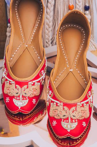 Red embroidered leather juttis