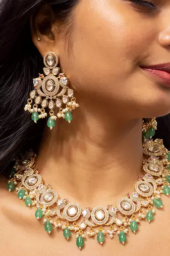 Elegant gold-toned kundan necklace set with green bead accents