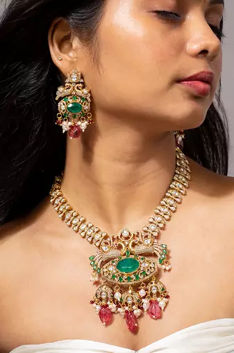 Traditional indian gold necklace set with green and pink gemstones