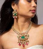Traditional indian gold necklace set with green and pink gemstones