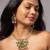 Traditional indian gold necklace set with green and pink gemstones