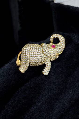 Gold-toned crystal elephant brooch with ruby eye accent by treemoda