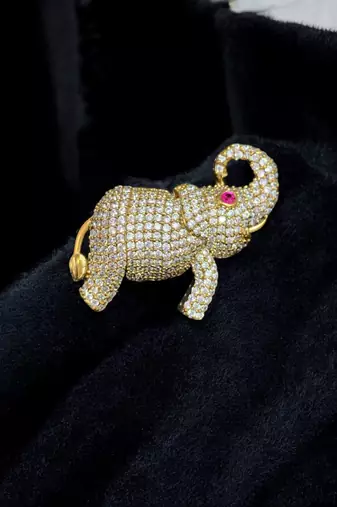 Gold-toned crystal elephant brooch with ruby eye accent by treemoda