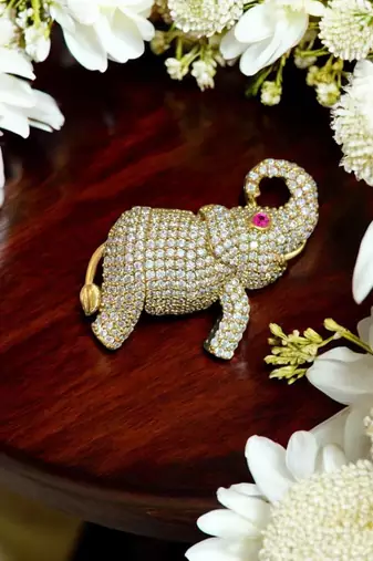 Gold-toned crystal elephant brooch with ruby eye accent