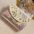 Osty lush – floral hand zari beaded clutch with dual handle | ivory base pastel embroidery bag- multy
