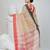 Elegant beige and red checked tant saree with contrast borders