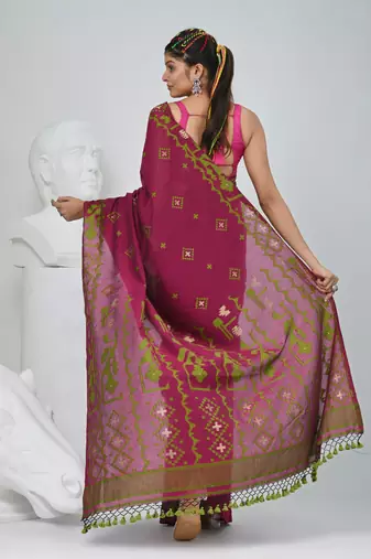 Magenta cotton saree with traditional woven patterns and tassel border