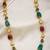 Single layer pearl necklace with red and green beads