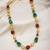 Single layer pearl necklace with red and green beads