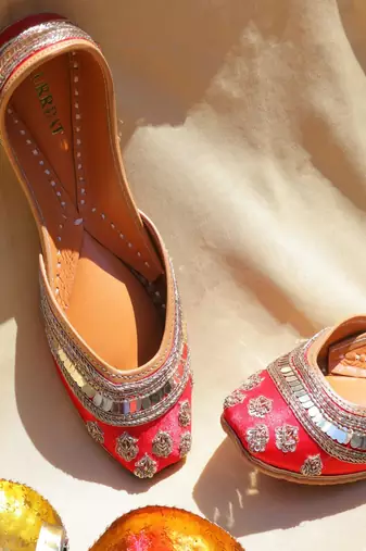 Red embroidered leather juttis