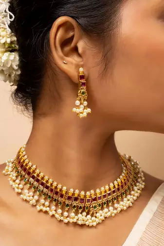 Traditional gold necklace with green and pink gemstones