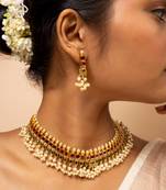 Traditional gold necklace with green and pink gemstones