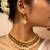 Traditional gold necklace with green and pink gemstones