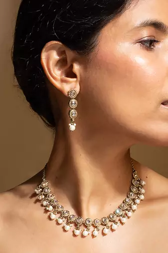 Elegant gold-toned traditional necklace and earring set with pearl accents