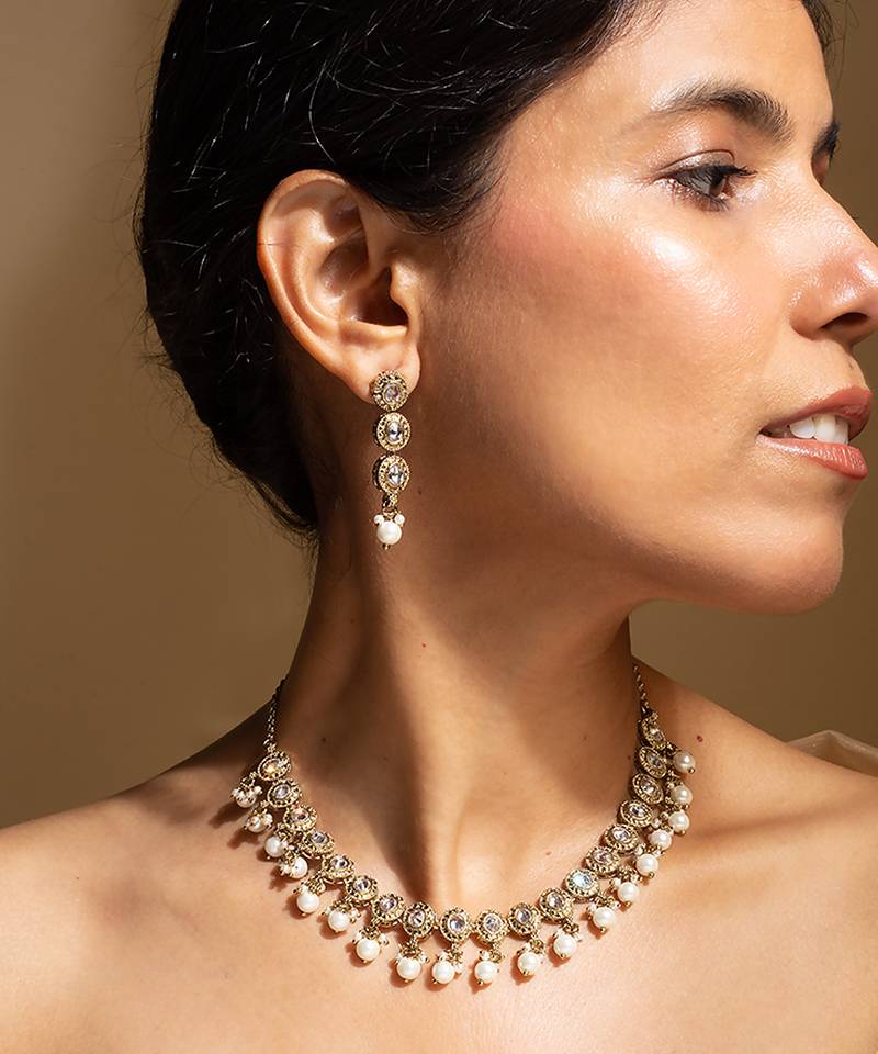 Elegant gold-toned traditional necklace and earring set with pearl accents