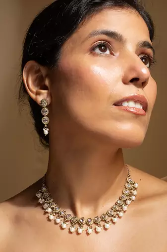 Elegant gold-toned traditional necklace and earring set with pearl accents