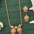Elegant gold-plated pendant and earring set with red and green stones