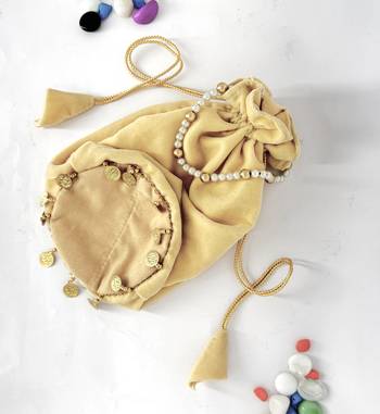 Cream plain with sikka zumkha lace on bottom round potli 3