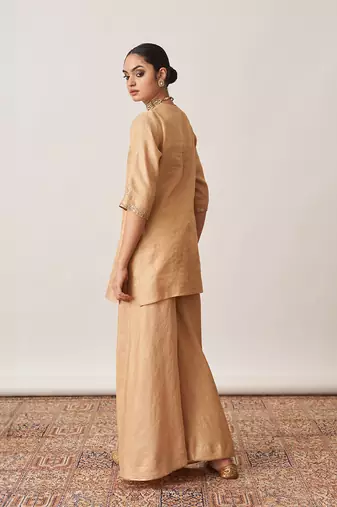 The gold silk tissue chanderi gharara set with pittha handwork