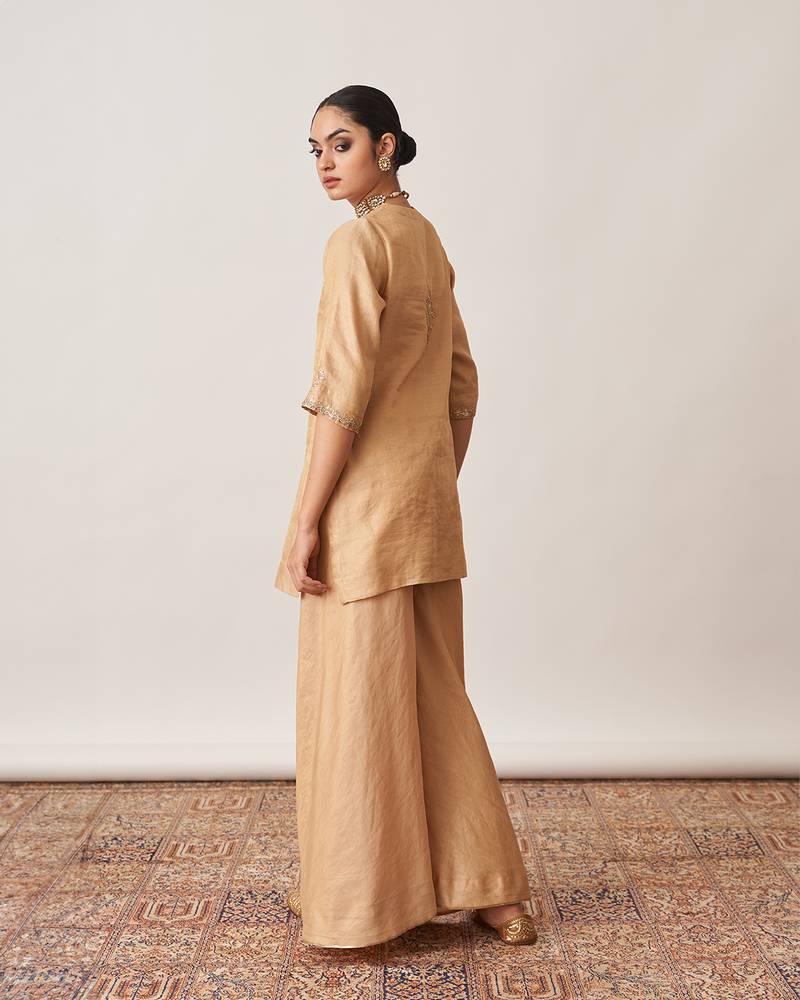 The gold silk tissue chanderi gharara set with pittha handwork