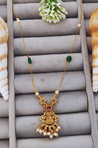 Antique gold lakshmi pendant chain with pearls and green stones for traditional and festive wear