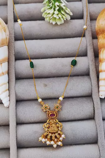 Antique gold lakshmi pendant chain with pearls and green stones for traditional and festive wear