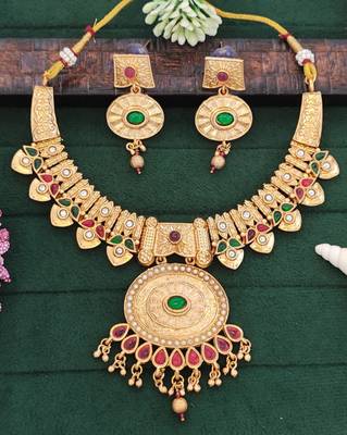 temple necklace set with green and ruby stones, intricate detailing and matching earrings 1