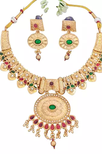 temple necklace set with green and ruby stones, intricate detailing and matching earrings