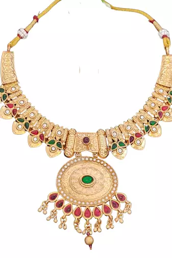temple necklace set with green and ruby stones, intricate detailing and matching earrings