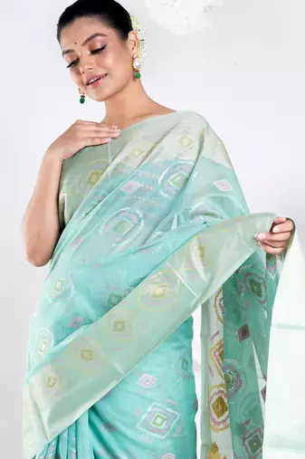 Banrasi kora organza saree in green color with multicolor abstract motifs and zari border