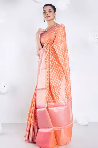 Banarasi kora organza saree in sunset orange color with golden border and booti