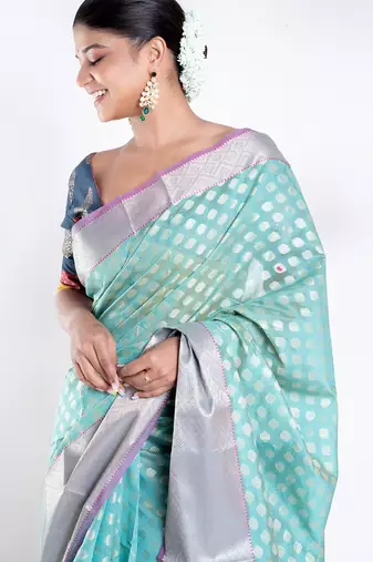Banarasi kora organza saree in green color with golden border and booti