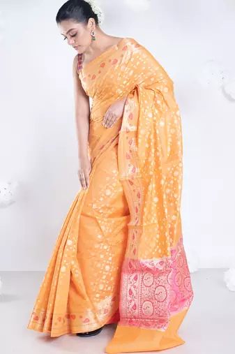 Banarasi kora organza saree in orange color with golden booti and border