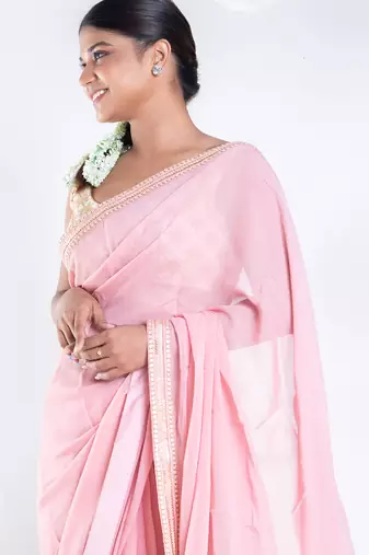 Pink color Georgette saree with golden embroidered border